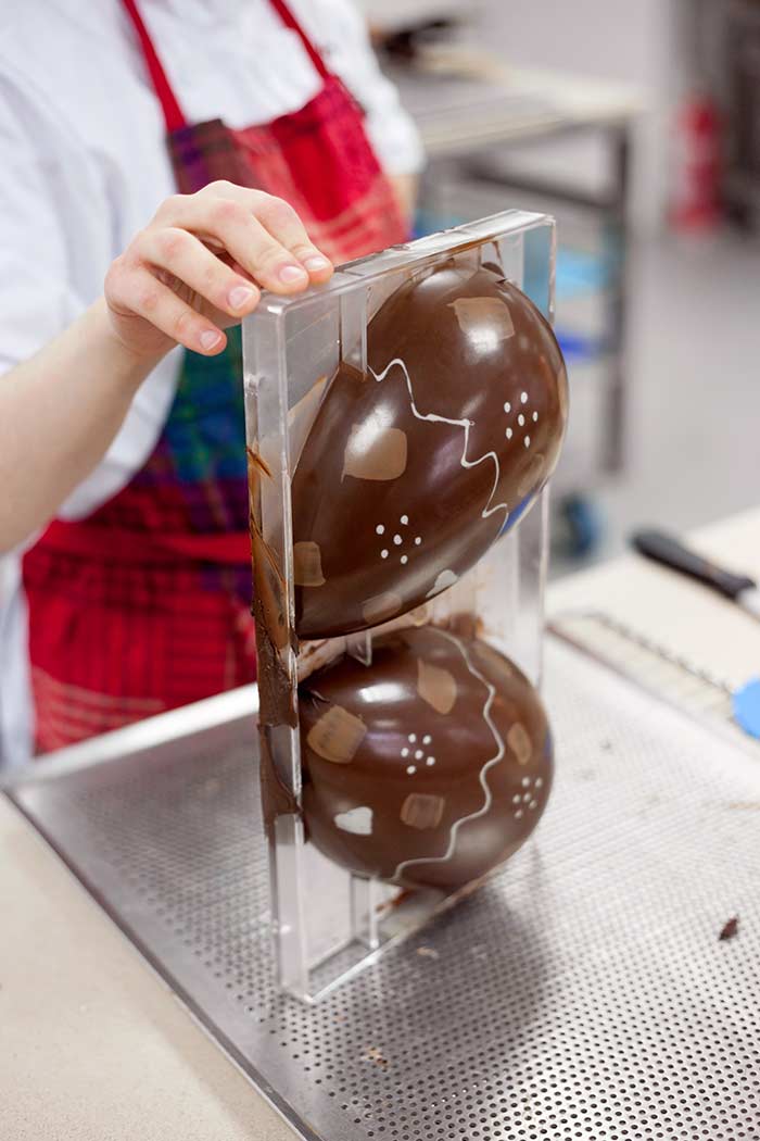 Chef removing chocolate egg from mould